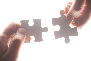 Image showing Puzzle, synergy and solution with hands of person on white background for achievement, goal and development. Mission, game and cooperation with jigsaw pieces for support, success and integration