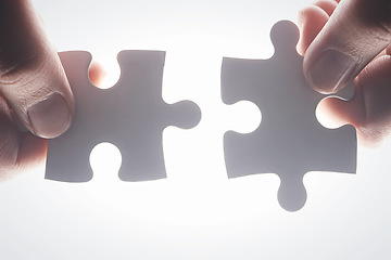 Image showing Puzzle, teamwork and synergy with hands of person on white background for achievement, solution or development. Mission, game and cooperation with of jigsaw piece for support, success and integration