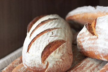 Image showing Background, sourdough bread or closeup in bakery of fresh loaves, carbs and rustic grain for nutrition. Artisan confectionery, food industry or selection of baked buns in cafe, grocery store or diner