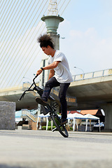 Image showing Urban, trick and man jump with bicycle for sports, balance and action in city street. Gen z male person, cycling stunt and challenge of biker in town for skill, performance risk and freedom of motion