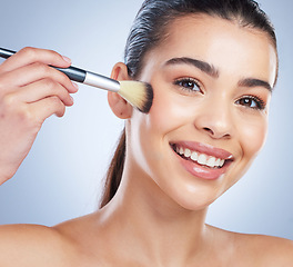 Image showing Beauty, cosmetic and portrait of woman with a makeup brush in studio for glamour facial routine. Self care, happy and young female model from Brazil with cosmetology face isolated by gray background.