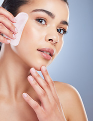 Image showing Gua sha, crystal and portrait of asian woman with skincare tool in studio for anti aging or fine lines on grey background. Rose quartz, stone and lady face wellness model with facial beauty massage