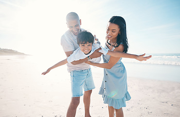 Image showing Beach, happy and parents flying their child on the sand by the ocean on a family weekend trip. Love, smile and boy kid holding and bonding with his young mother and father on tropical summer holiday.