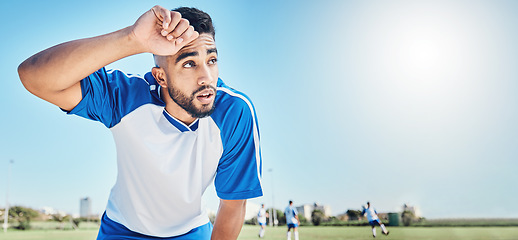 Image showing Football player, tired and man sweating outdoor on a field for sports and fitness competition. Male soccer or athlete person on a break while exhausted from training workout with mockup banner space