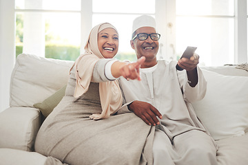 Image showing Happy, muslim and watching tv with old couple on sofa for streaming, movie and funny. Television, smile and relax with senior man and woman in living room at home for comedy, retirement and lounge