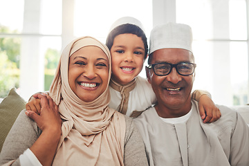 Image showing Portrait, Islam and grandparents with child for Eid with happy family in home with culture in Indonesia. Senior Muslim man, old woman in hijab and kid with smile on face on sofa together in lounge.