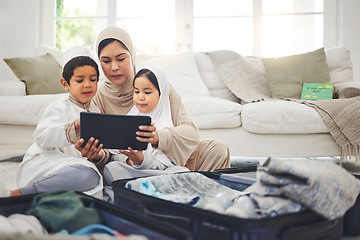 Image showing Travel, tablet and Muslim family with suitcase packing for holiday, vacation and religious trip. Home, luggage and mom with kids on digital tech and clothes in bag for journey, adventure and tourism