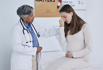 Image showing Senior doctor, pregnant woman and headache in consultation, checkup or appointment at hospital. Mature female person, medical or healthcare expert checking patient in maternity or pregnancy at clinic