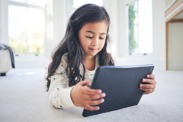Image showing Young girl, tablet and game app or cartoon streaming online with internet, elearning and relax on carpet in house. Watch animation film, female kid at home and website, entertainment and subscription