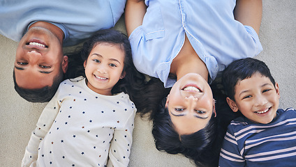 Image showing Above, portrait and happy family on a floor relax, bond and playing in their home on the weekend. Face, smile and top view of children with young parents in a bedroom with love, fun and chilling