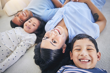 Image showing Top view, portrait and happy family on a floor relax, bond and playing in their home on the weekend. Face, smile and above children with young parents in a bedroom with love, fun and chilling