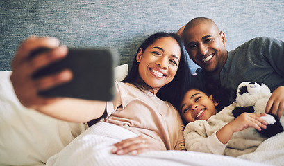 Image showing Family selfie, parents and child in a bed together with love, care and security or comfort. Woman, man and kid relax with a happy smile for quality time, memory or profile picture in a home bedroom