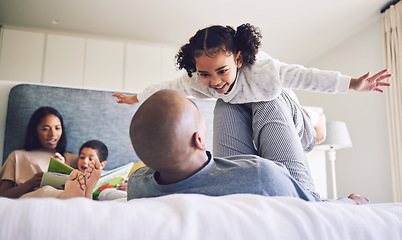 Image showing Family home, parents and child playing on a bed together with love, care and security or comfort. Man and girl kid with a happy smile, fun game and quality time in bedroom to fly or relax in morning