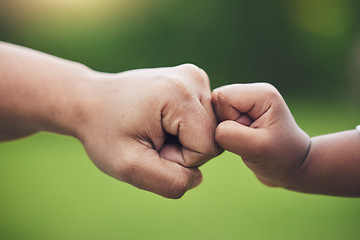 Image showing Fist bump, hands of baby and father with support together or gesture of success or trust in family on blurred background. Hand, bumping fists and dad with son or sign of solidarity or celebration