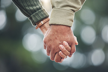 Image showing Love, holding hands and couple together in partnership, marriage or people with trust, bonding or moment in nature with bokeh background. Hand, support and unity with a soulmate or romantic partner