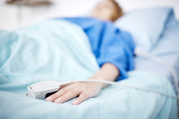 Image showing Person, hand or sleeping in hospital bed for medical treatment, surgery and icu operation in clinic. Tired, blur or sick patient lying or resting in emergency room for healthcare or wellness recovery