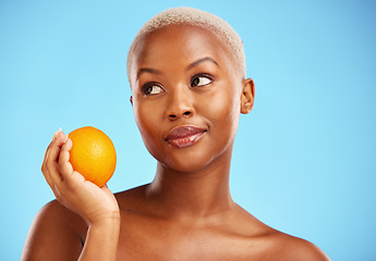 Image showing Orange, thinking and black woman with skincare, natural beauty and vitamin c against a blue studio background. Female person, ideas and model with citrus fruit, health and wellness with dermatology