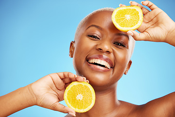 Image showing Portrait, orange and beauty with a model black woman in studio on a blue background for nutrition. Smile, fruit and skincare with a happy young person holding a snack for natural health or wellness