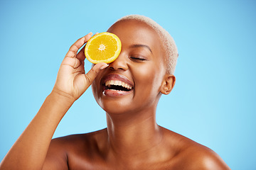 Image showing Orange, beauty and funny with a model black woman in studio on a blue background for natural nutrition. Fruit, skincare and smile with a happy young female person laughing for health or wellness