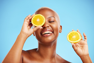 Image showing Skincare, orange and smile with a model black woman in studio on blue background for treatment. Face, beauty and fruit with a happy young female person holding a slice for natural health or wellness