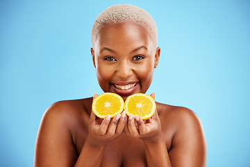 Image showing Portrait, skincare and fruit or nutrition with a black woman in studio on a blue background for health. Smile, beauty and orange with a happy young female person holding food for natural wellness