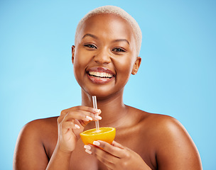 Image showing Happy black woman, portrait and orange for vitamin C, diet or natural nutrition against a blue studio background. African female person smile with citrus fruit and straw for healthy wellness or juice