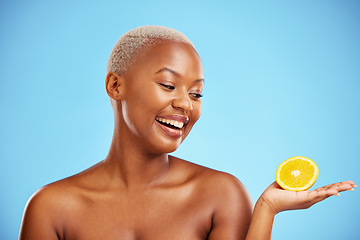 Image showing Orange, beauty or health and a model black woman in studio on blue background with fruit in the palm of her hand. Natural, skincare or diet with a happy young person holding healthy food for wellness