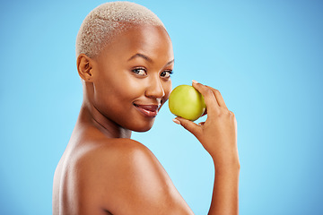 Image showing Happy black woman, portrait and apple for nutrition or healthy diet against a blue studio background. African female person smile with natural organic green fruit for food snack, health and wellness