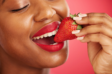 Image showing Strawberry, lipstick and woman lips eating, eco friendly product and color choice or dermatology. Happy mouth of african person or model with skincare, fruit and vegan makeup on studio red background