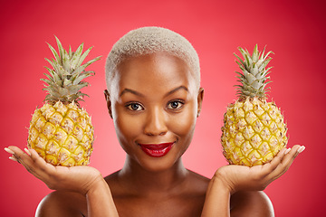 Image showing Woman, pineapple and studio portrait for skincare, beauty and diet for wellness, health and red background. African model girl, fruits and face with makeup, nutrition and food choice with cosmetics