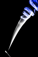 Image showing Stick with a blue smoke. Isolated on a black background