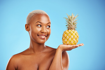 Image showing Black woman, pineapple and palm for diet, natural nutrition or health against a blue studio background. African female person smile in happiness holding organic fruit for vitamin, fiber or wellness