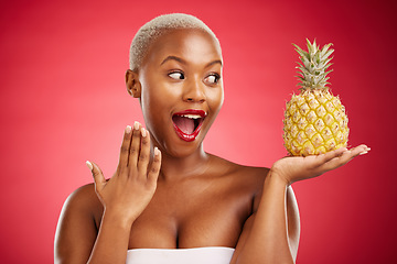 Image showing Pineapple, surprise and beauty of a woman in studio for healthy food, diet or fruit. Black female model with makeup on red background for wellness glow, natural cosmetics and wow skin care benefits