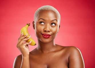 Image showing Beauty, phone call and woman with a banana or acting angry, pretending and fake conversation on red background. Playful mobile communication, studio and girl with crazy and funny chat with fruit