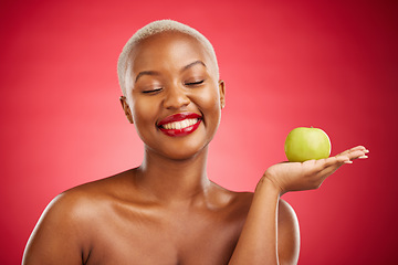 Image showing Happy black woman, apple and natural nutrition for healthy diet against a red studio background. African female person smile with natural organic green fruit for food snack, health and wellness