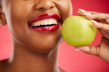 Image showing Woman, mouth and apple in diet, nutrition or health and wellness against a red studio background. Closeup of female person smile with lipstick or natural organic fruit in vitamin, fiber or food snack