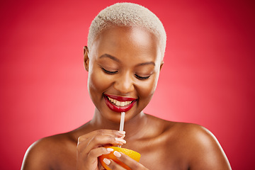 Image showing Happy black woman, orange and vitamin C for diet or natural nutrition against a red studio background. African female person smile and drinking organic citrus fruit with straw on mockup space