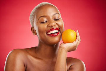 Image showing Orange, smile and black woman with natural beauty, dermatology and vitamin c on a red studio background. Female person, happy or model with citrus fruit, health or wellness with cosmetics or skincare