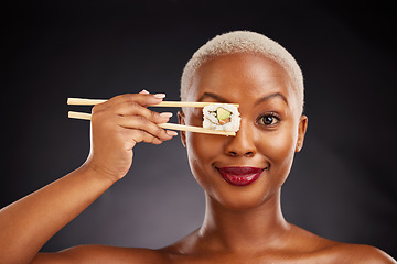 Image showing Woman, face and sushi with chopsticks in studio for healthy eating, beauty and food. Portrait of a black female model with makeup on a dark background for wellness, diet or seafood advertising