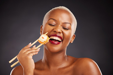 Image showing Face, laugh and woman with sushi and chopsticks in studio for healthy eating, beauty or food. Black female model with makeup on a dark background for wellness glow, diet nutrition or funny seafood