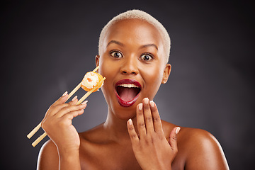 Image showing Face, surprise and woman with sushi and chopsticks in studio for healthy eating, beauty or food. Black female model with makeup on dark background for wellness glow, wow diet or seafood portrait