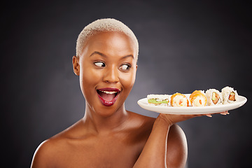 Image showing Face, surprise and woman with sushi plate in studio for healthy eating, beauty or food. Excited black female model with makeup on dark background for wellness glow, wow diet or seafood advertising