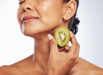 Image showing Beauty, skincare and mature woman with kiwi in studio isolated on a white background. Food, fruit and natural model with nutrition for wellness, healthy diet and vitamin c for anti aging cosmetics.