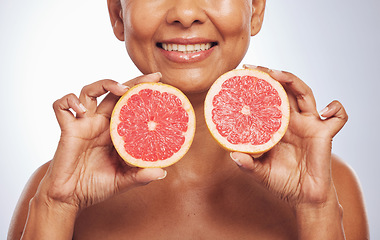 Image showing Skincare, hands and happy woman with grapefruit in studio isolated on a white background. Food, natural fruit and mature model with nutrition for wellness, healthy diet and vitamin c for anti aging.