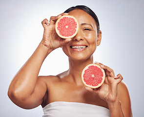 Image showing Face, happy and senior woman with grapefruit in studio isolated on a white background. Skincare, natural fruit and portrait of model with food for nutrition, healthy diet and vitamin c for anti aging