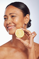 Image showing Thinking, orange and senior woman with skincare, dermatology and treatment against a white studio background. Mature female person, happy lady or model with citrus fruit, natural beauty and vitamin c