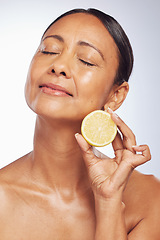 Image showing Cosmetics, orange and senior woman with skincare, dermatology and vitamin c against a white studio background. Mature female person, self care and model with citrus fruit, natural beauty and health