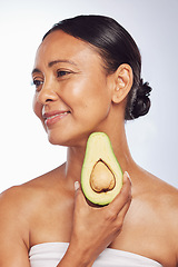 Image showing Avocado, skincare or happy mature woman with fruit for cleaning, detox or healthy skin with beauty. Wellness, white background or senior model smiling for natural dermatology treatment in studio