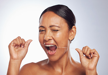 Image showing Dental flossing, portrait or mature woman cleaning teeth for beauty or wellness in studio on white background. Wink, self care or healthy senior female model grooming her tooth or mouth for hygiene