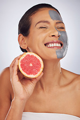 Image showing Woman, skincare, with grapefruit and face mask with charcoal, clay or natural beauty product for wellness, detox or nutrition. Fruit, healthy cosmetics and girl happy with vitamin c or facial care